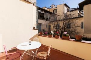 a balcony with a table and chairs on a building at Incantevole appartamento in Oltrarno in Florence