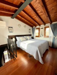 a bedroom with a large bed in a room with wooden ceilings at Porto Valentino Apartment in Sirmione
