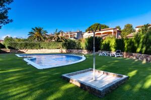 a swimming pool in a yard with a green lawn at Fabulosa Saxum : entre mar y montañas in Bonmont Terres Noves