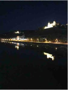 a view of a city at night with a body of water at Wohnung Stadtmitte Würzburg, Küche, Balkon. in Würzburg