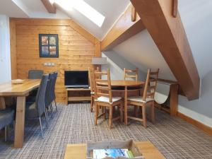 a dining room with a table and a tv at Les balcons des aiguilles in La Toussuire