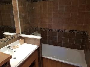 a bathroom with a sink and a bath tub at Les balcons des aiguilles in La Toussuire