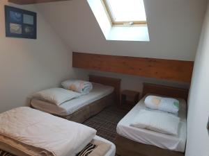 a attic room with two beds and a skylight at Les balcons des aiguilles in La Toussuire