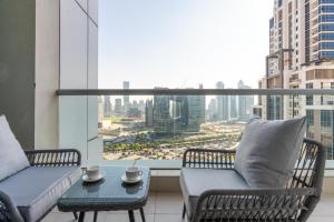 uma varanda com 2 cadeiras e uma mesa em frente a uma janela em Spacious Recently Refurnished 2 Bedroom with Large Terrace in the Heart of Business Bay, next to Metro and Dubai Downtown em Dubai