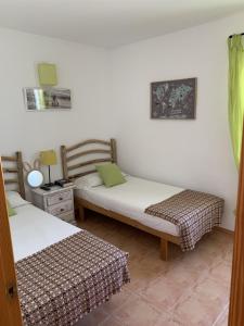a room with two beds and a night stand at Chalet con piscina en Menorca in Cala en Bosc