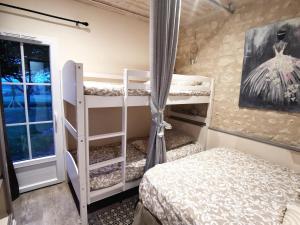 a bedroom with two bunk beds and a window at Gîte de charme dans un cadre calme et reposant in Châtellerault