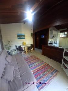 1 dormitorio con 1 cama y 1 mesa con sillas en Casa e kitnet Morada Aguiar - casa en Ilha Grande