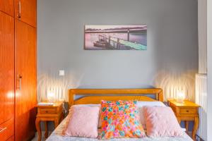 a bedroom with a bed with two night stands and two tables at Dimitra Apartment in Kassiopi