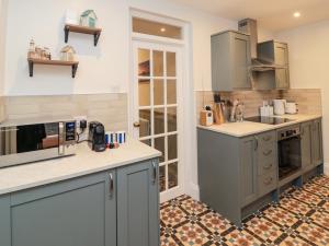 a large kitchen with gray cabinets and appliances at The Cobbles in Alnwick