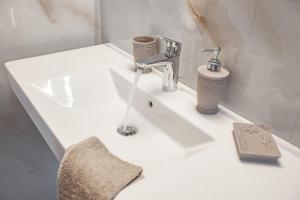 a white bathroom sink with a faucet on it at Dimitra Apartment in Kassiopi +15 photos