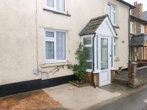 a white house with a white door and a plant at Rose Villa in Builth Road