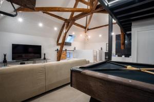 a living room with a pool table and a couch at Le Saint-André - Clim - Loft romantique avec Jacuzzi in Buxy +20 photos
