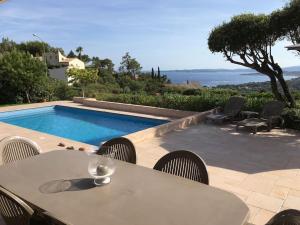 - une table et des chaises à côté de la piscine dans l'établissement Les Issambres - 8 pers, piscine privée, belle vue mer, aux Issambres