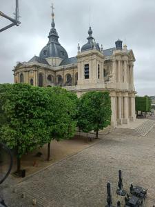 un grand bâtiment avec des arbres devant lui dans l'établissement L’ESPERANCE, à Versailles