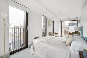 a bedroom with a large white bed and a large window at Stunning 3 Bedroom Penthouse Private Terrace AC in London