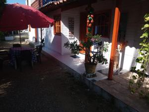 eine Veranda eines Hauses mit einem Tisch und einem Sonnenschirm in der Unterkunft Al lado del mar, Cabañas Polaris, Coveñas in Coveñas