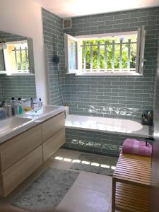 une salle de bain avec une baignoire et un lavabo et une baignoire dans l'établissement Les Issambres - 8 pers, piscine privée, belle vue mer, aux Issambres