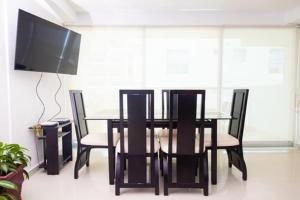 a dining room with a table and chairs and a flat screen tv at Apartmento Edificio Porto Vento in Cartagena de Indias