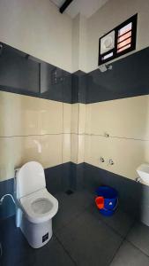 een badkamer met een wit toilet en een wastafel bij Caffeine Villa in Kaniyāmbetta
