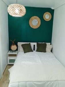 a bedroom with a white bed with a green wall at Muy bonito piso en los cristianos centro in Los Cristianos