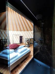 sypialnia z łóżkiem w pokoju z drewnianą podłogą w obiekcie Glamping jurty Czapla w Wałczu