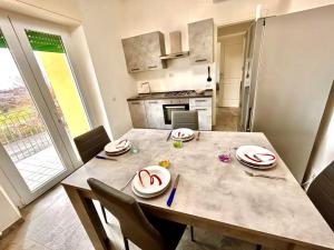 a kitchen with a table and chairs and a dining room at BILO LEONDINO nuovo appartamento con aria condizionata in Numana