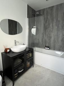 a black and white bathroom with a sink and a tub at The Bunga, Portrush in Portrush