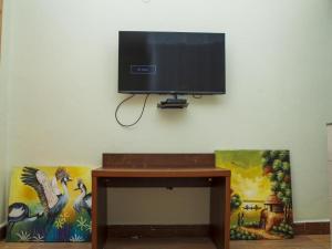 TV de pantalla plana colgada en la pared en MT. Rwenzori Golf Resort & Spa, en Rubona