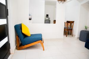 uma sala de estar com uma cadeira azul e uma almofada amarela em Hotel Bungalows Casa Blanca em Tenancingo de Degollado