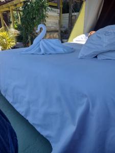 Una cama blanca con un cisne encima. en Hotel Kira, en Jericó