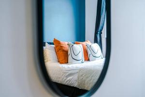 沃靈頓的住宿－Cozy and Stylish 1 Bedroom Flat in Warrington，一张带枕头的沙发的镜子反射