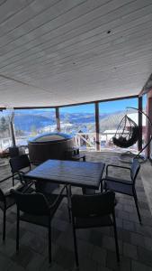 a table and chairs on a patio with a view at Порядна Ґаздиня in Yaremche