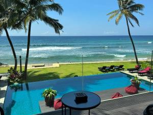 a view of the ocean from a resort with a swimming pool at DORMERO Hotel Sri Lanka Hikkaduwa Beach in Hikkaduwa