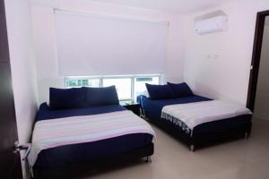 una camera da letto con due letti e una finestra di Apartmento Edificio Porto Vento a Cartagena de Indias Altre 59 foto