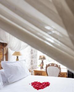 - une chambre avec un lit orné d'une fleur rouge dans l'établissement Chateau Du Boisniard, à Chambretaud