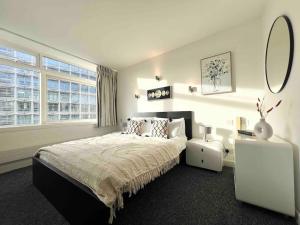 1 dormitorio con 1 cama grande y espejo en 2 Bed Apartment- Central London en Londres
