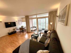 a living room with a large couch and a living room with at 2 Bed Apartment- Central London in London