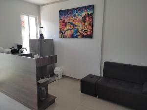 una sala de estar con sofá y una pintura en la pared en Apartaestudio 201 - Casa Hotel Anita, en Tuluá