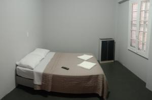 ein Schlafzimmer mit einem Bett mit zwei Handtüchern darauf in der Unterkunft Hotel Rest in Porto Alegre