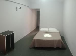 a white room with a bed and a sink at Hotel Rest in Porto Alegre