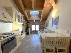 uma cozinha com mesa e cadeiras num quarto em Affittimoderni Ponte di Legno Ski em Ponte di Legno