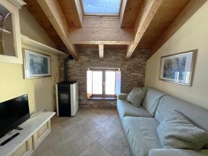 a living room with a couch and a tv at Affittimoderni Ponte di Legno Ski in Ponte di Legno