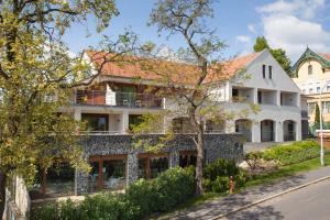 a large white house with a tile roof at Hotel Bonvino Badacsony in Badacsonytomaj