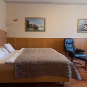 a hotel room with a bed and a chair at Comfort Hotel Am Kurpark GmbH in Bad Homburg vor der Höhe