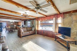 uma sala de estar com um sofá e uma televisão de ecrã plano em Authentic Log Cabin in Pineville about 2 Mi to River! 