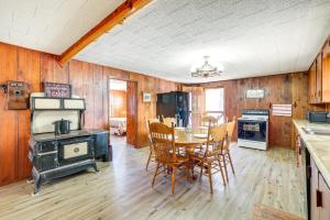uma cozinha com uma mesa, cadeiras e um fogão em Authentic Log Cabin in Pineville about 2 Mi to River! 