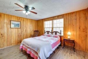 - une chambre avec un lit et un ventilateur de plafond dans l'établissement Authentic Log Cabin in Pineville about 2 Mi to River!, 