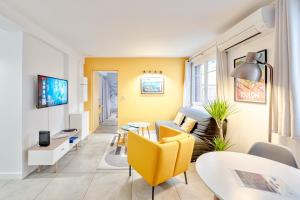 - un salon avec un canapé jaune et une table dans l'établissement Ô Repos des Artistes - Classified apartments***, à Toulon