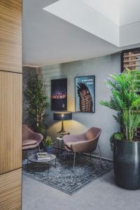 - un salon avec deux chaises et une plante en pot dans l'établissement 3 VIE Restaurant & Rooms, à Acquarossa