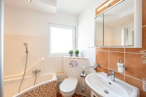 大蓋勞的住宿－AM01 Haus mit Garten & Terrasse!，一间带水槽、卫生间和镜子的浴室
